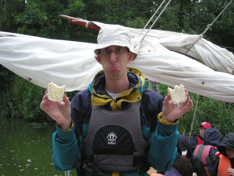 Tore wearing a bucket hat looks sad holding two halves of a bread roll.